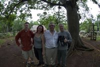 Four people in front of a tree.