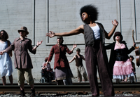 Row of dancers on railroad track.