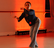One woman dancing on orange background.